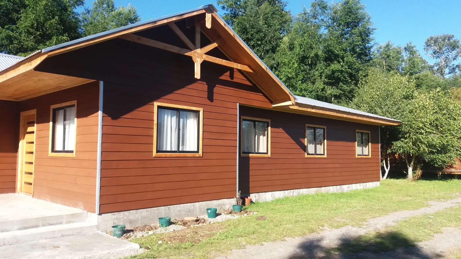 Costado de la casa con ventanas termopanel y revestimiento de madera