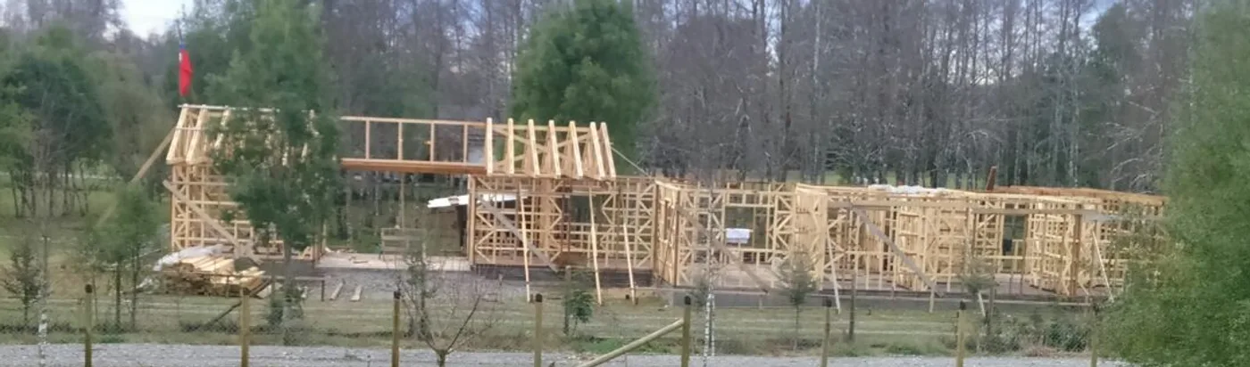 Estructura completa de pino de una vivienda Casas Cacique en Villarrica, con la bandera de los tijerales
