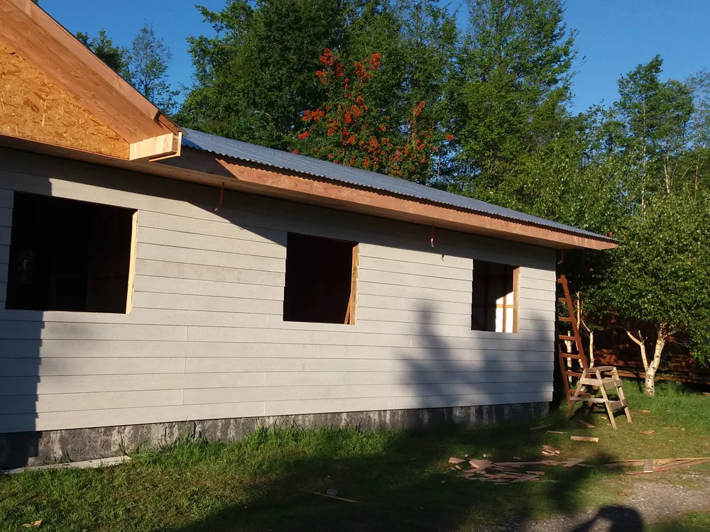 Cubierta metálica y revestimiento exterior instalados sobre la estructura de madera, obra Casas Cacique