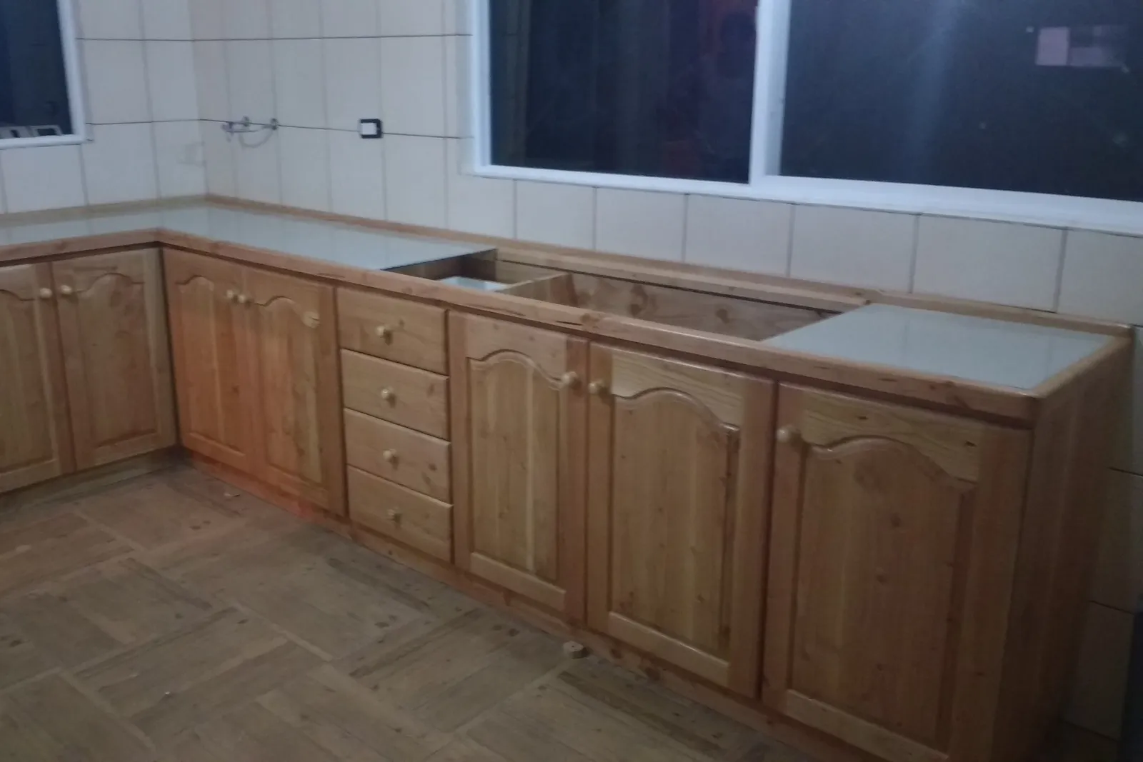 Muebles bajos de pino en L, instalados en obra