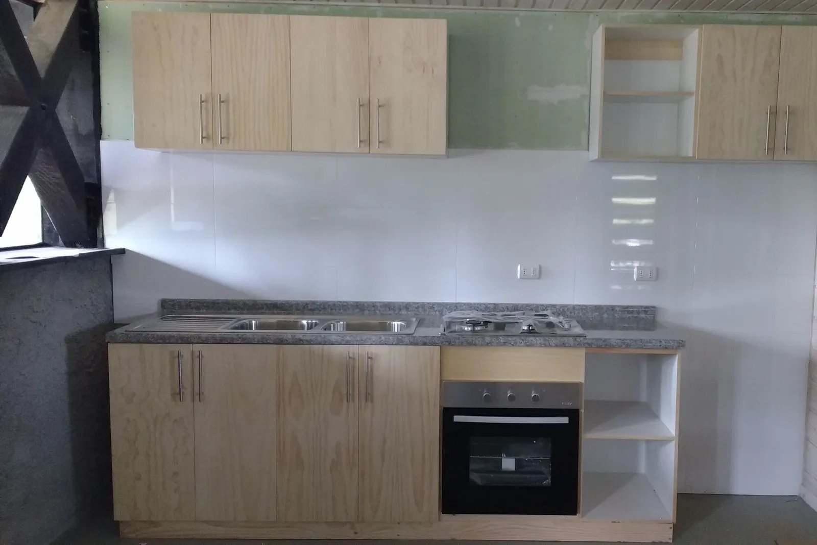 Cocina completa de la Línea Recta: muebles de madera con puerta lisa, tiradores metálicos y horno empotrado