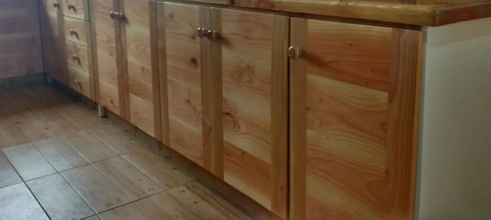 Muebles bajos de madera con tiradores metálicos, instalados en obra